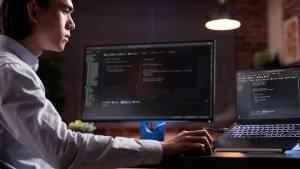 IT professional studying for CompTIA A+, Network+, and Security+ certifications. Man working on computer code.