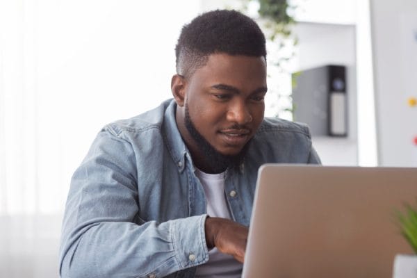 Geography student using laptop. Adult matric student studying online.