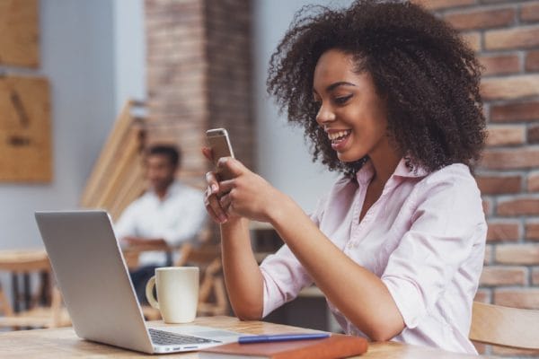 Life Sciences: Smiling woman with laptop and phone. Adult education, matriculation.