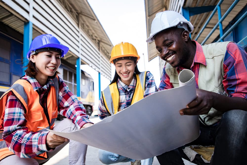 NEBOSH International General Certificate in Occupational Health and Safety students. Construction workers reviewing plans.