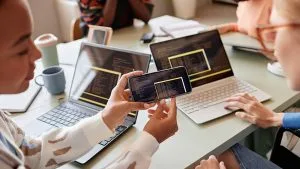 Interactive JavaScript site development: Developers working on code with laptops and mobile phone.