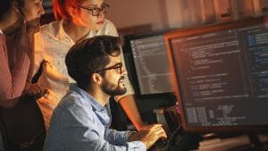 Machine learning specialist team working on code. Programming principles.