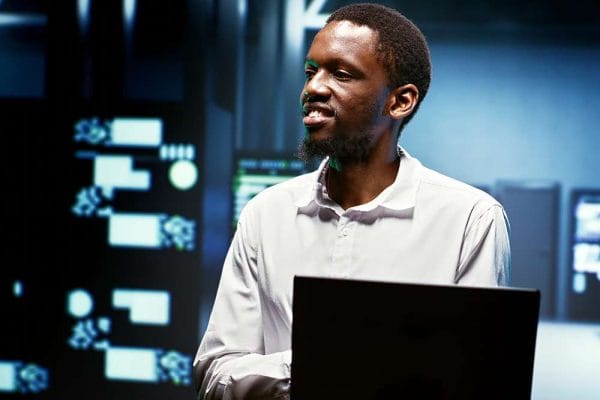 AWS Certified Solutions Architect Associate, man with laptop in server room.