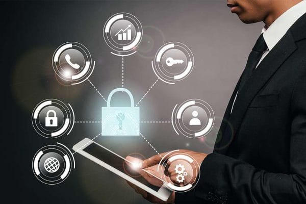 Certified in Cybersecurity (CC). Man uses tablet with cybersecurity lock icon and related security symbols.