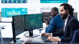 CompTIA Data+ professionals analyzing data on screens. Data analysis, charts, and graphs are visible.