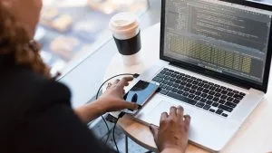 Microsoft DevOps solutions: Developer coding on laptop. Designing & implementing software with AZ-400.