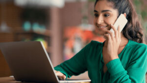 Adult education: Woman studies Setswana, using laptop and phone. Home language learning.