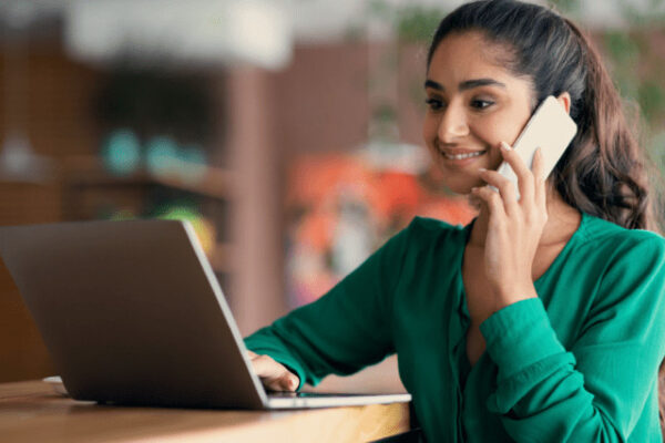 Adult education: Woman studies Setswana, using laptop and phone. Home language learning.