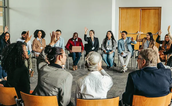 Adult workshop group learning. Diverse people in circle raising hands. Training session.